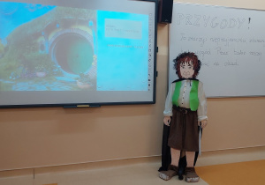 Figura Bilba Bagginsa stojąca przy tablicy prezentującej temat lekcji