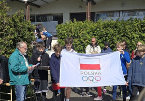 uczniowie naszej szkoły z flagą olimpijską