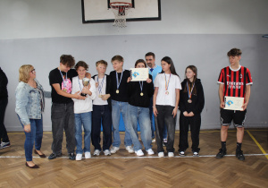 Uczennice i uczniowie klas 7 i 8 z medalami i pucharem za osiągnięcia sportowe