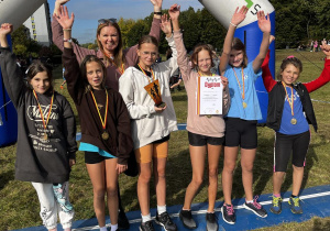 Grupa uczniów z trofeami po biegach