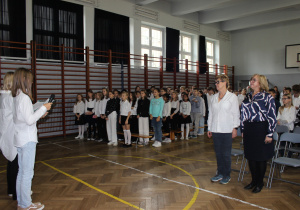 zebrani uczniowie i Rada Pedagogiczna w sali gimnastycznej