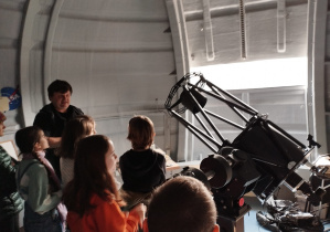 uczniowie oglądają teleskop